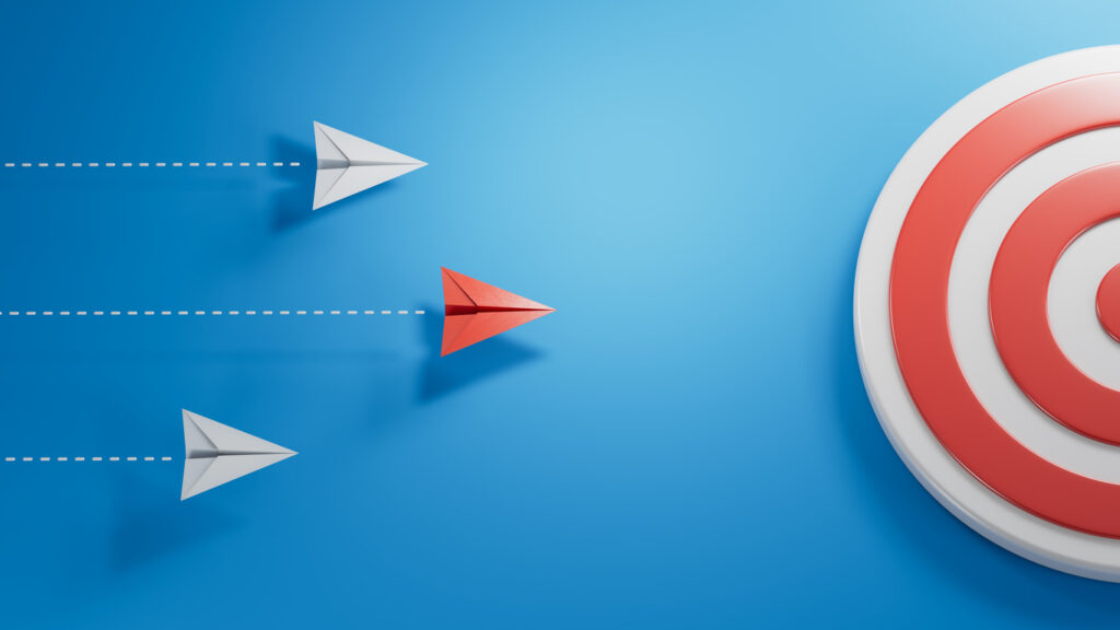 Paper airplanes flying towards a target, illustrating strategic focus and goal-oriented planning in IT asset disposition (ITAD) and lifecycle management.