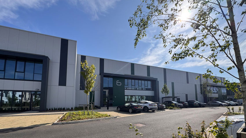 Services_Floating Modern Astralis Technology facility with large windows, greenery, and parked cars, representing secure IT lifecycle services and sustainability.