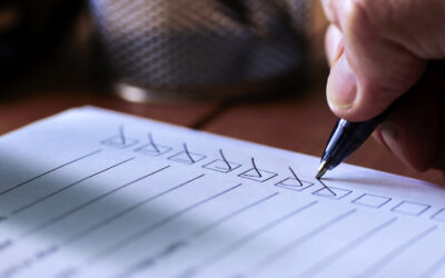 Hand checking off items on a checklist, symbolizing IT asset management and vendor selection processes in ITAD.