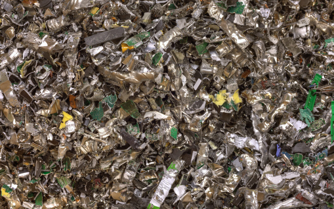Shredded electronic waste, showcasing metallic and circuit board fragments, representing sustainable IT asset disposal and recycling services by Astralis Technology.