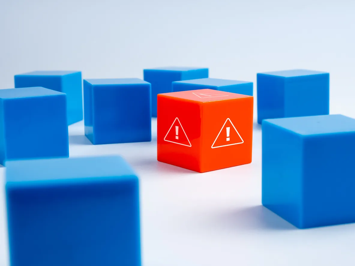 Orange warning block among blue blocks, symbolizing risks in data centre relocation and decommissioning processes.