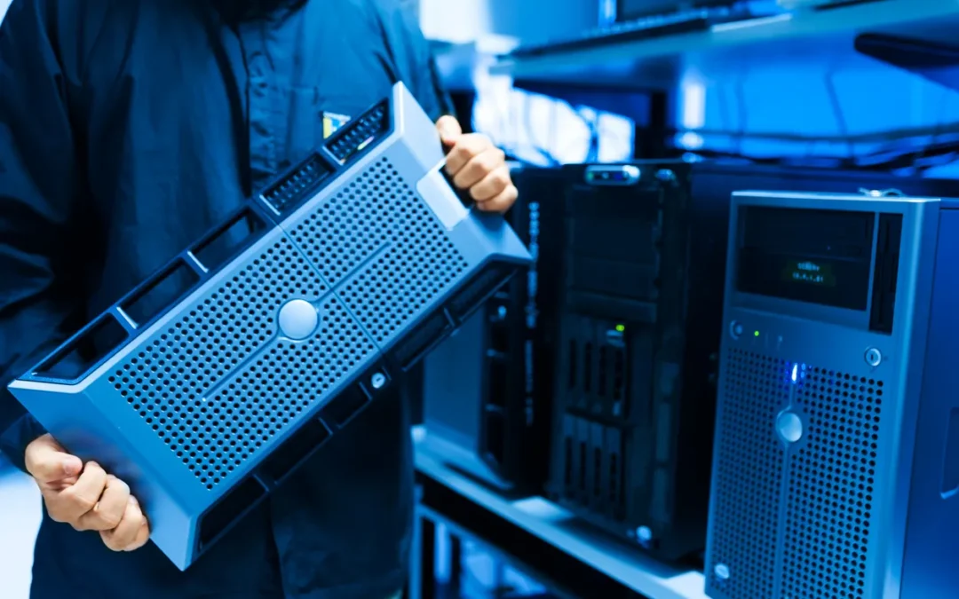 Technician holding a server component in a data centre, emphasizing IT asset management and secure server disposal.