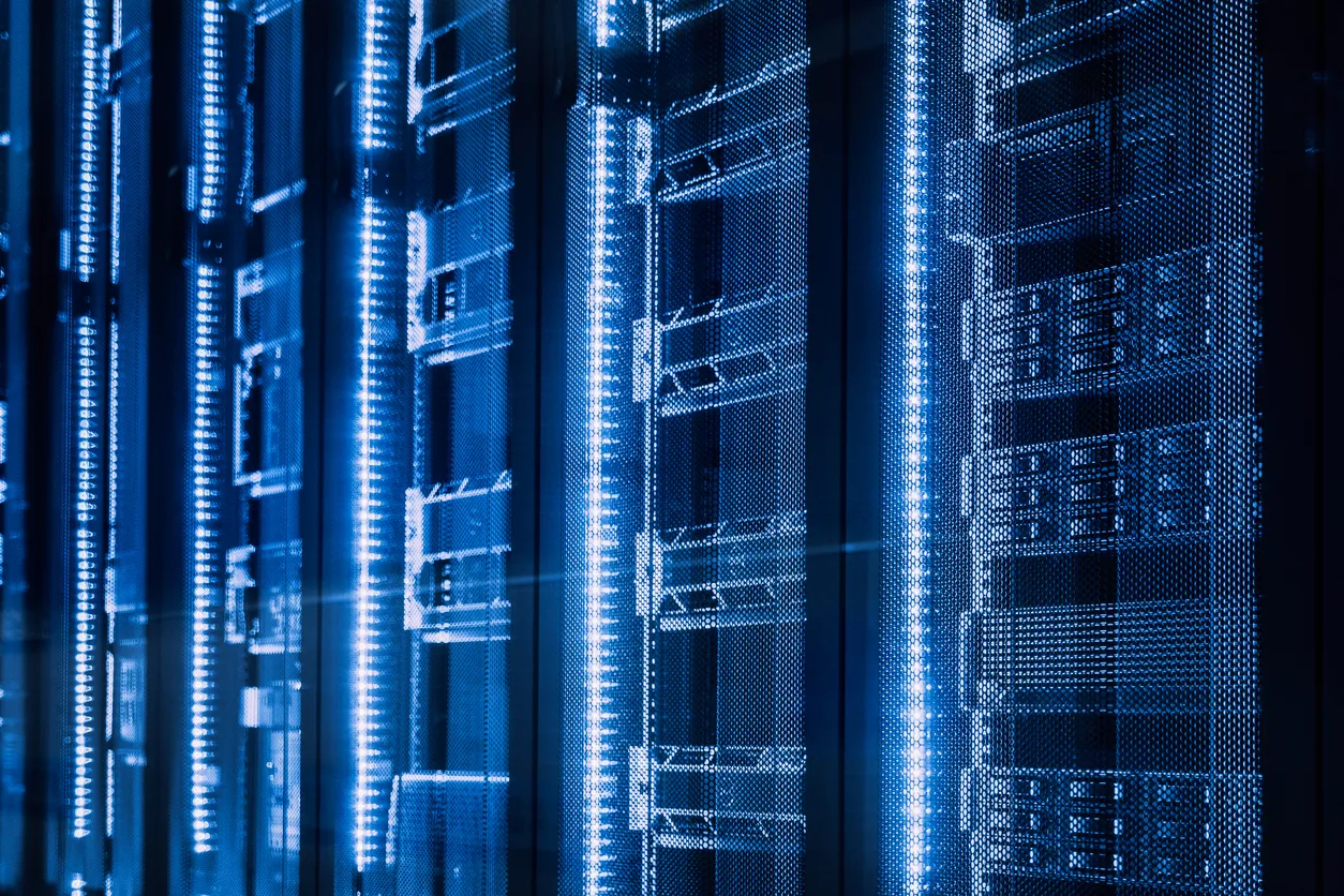 Server racks illuminated with blue lights, representing secure IT infrastructure for compliant server disposal in the UK.