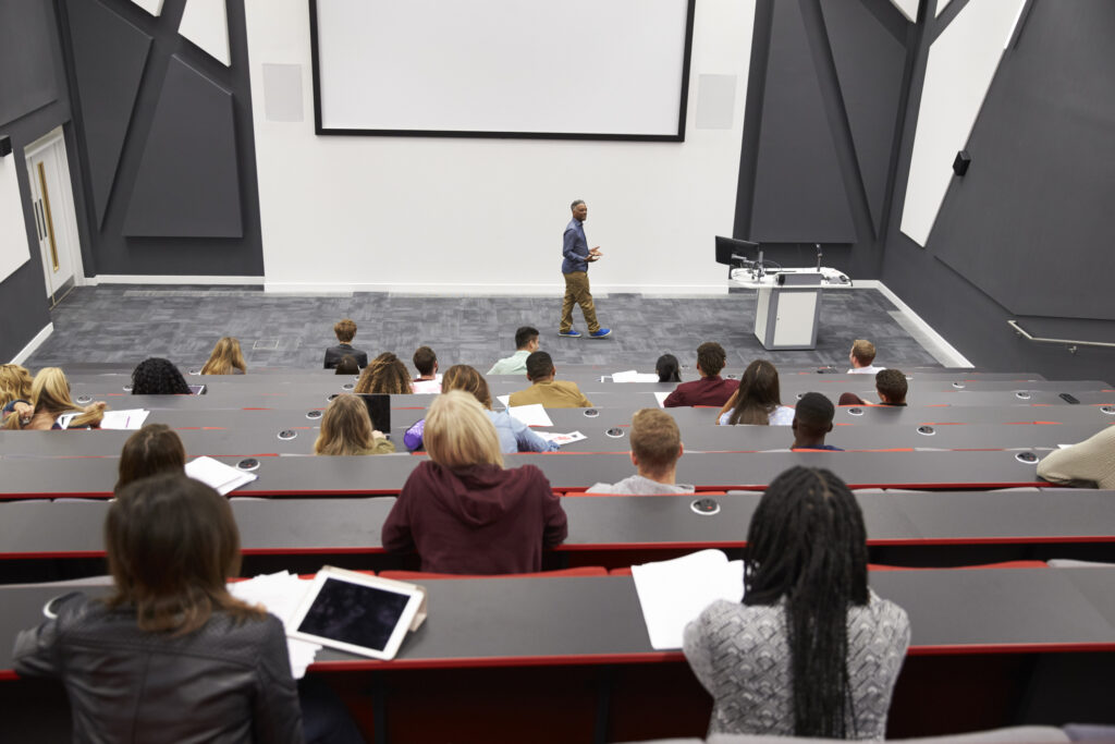 Students attending a lecture in a modern university lecture theatre.